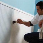 a contractor painting interior wainscoating