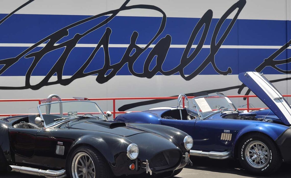 Several Shelby Cobras in front of the newly repainted car company's corporate headquarters