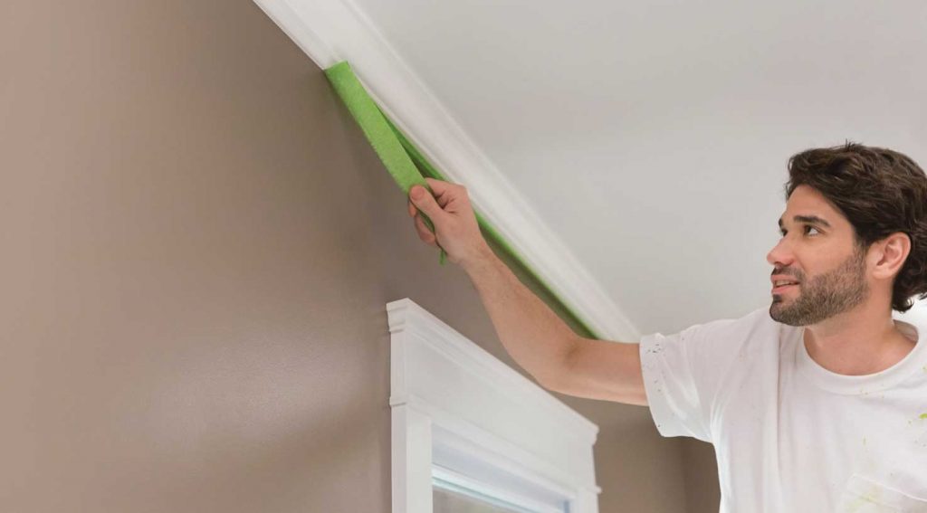 contractor removing FrogTape from crown moulding
