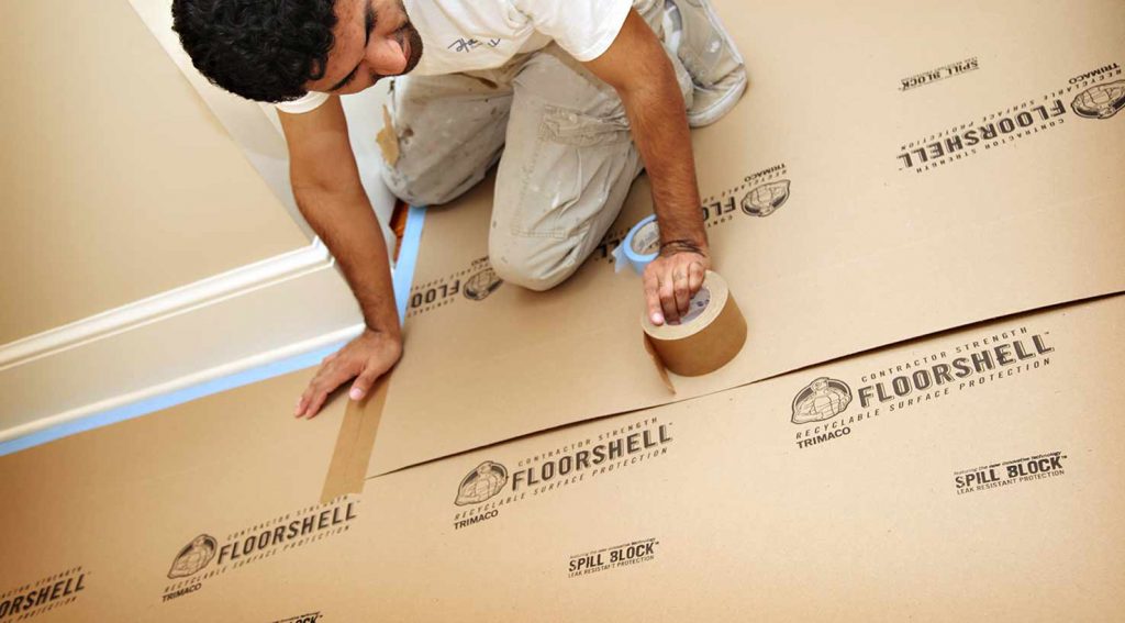 a contractor installing FloorShell® Heavy Duty Temporary Surface Protector