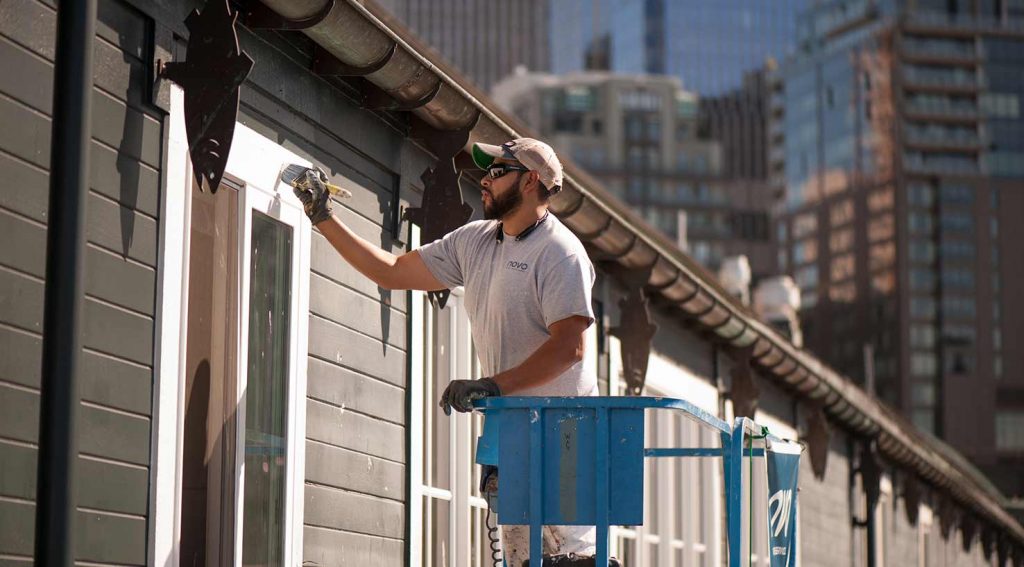 A painter works on the Seattle Aquarium at Pier 59 on Puget Sound