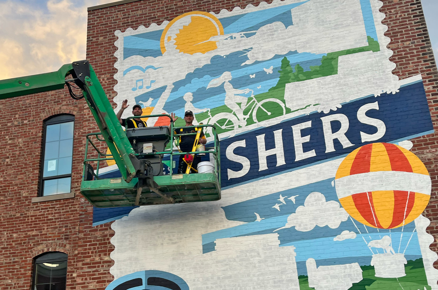 Wilkinson Brothers painting the Greetings from Fishers IN mural