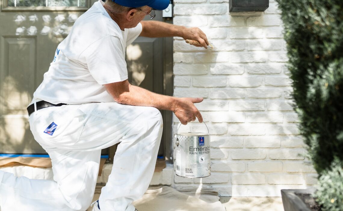 Professional painting contractor painting brick exterior