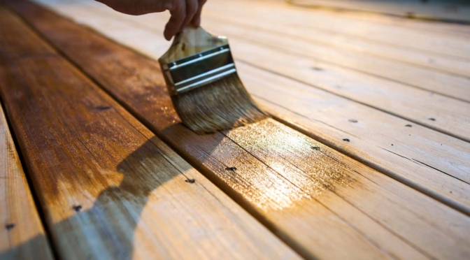 A contractor applies finish to a deck in this example image.